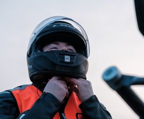 Homme qui attache son casque de moto